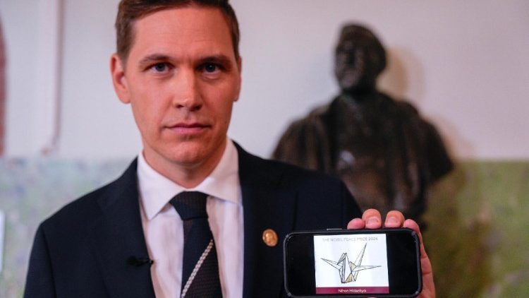 O chefe do Comit&ecirc; noruegu&ecirc;s do Nobel, Jorgen Watne Frydnes, posa com um telefone celular exibindo o logotipo da organiza&ccedil;&atilde;o japonesa Nihon Hidanky, vencedora do Pr&ecirc;mio Nobel da Paz de 2024, durante uma coletiva de imprensa no Instituto Noruegu&ecirc;s do Nobel em Oslo, Noruega, em 11 de outubro de 2024. 