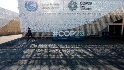 Um participante passa pelo banner de boas-vindas do lado de fora do local da Conferência das Nações Unidas sobre Mudanças Climáticas, COP29, em Baku, Azerbaijão.
