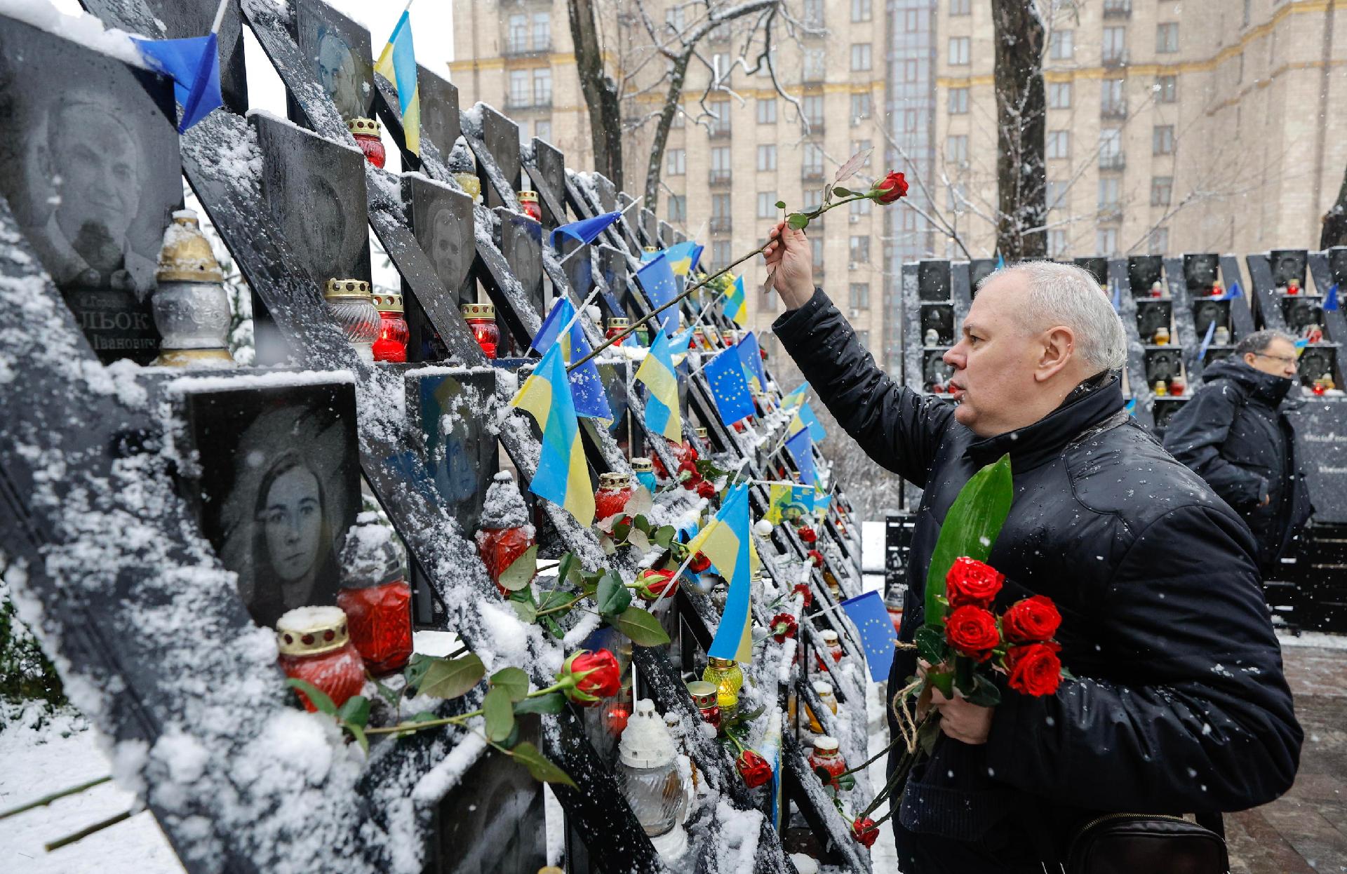 Ucranianos depositam flores em meio à neve no memorial aos "Heróis dos Cem Celestiais", em homenagem aos ativistas mortos durante os protestos do Euromaidan em 2014, perto da Praça da Independência em Kiev, Ucrânia, em 21 de novembro de 2024, em meio à invasão russa em andamento. EPA/SERGEY DOLZHENKO