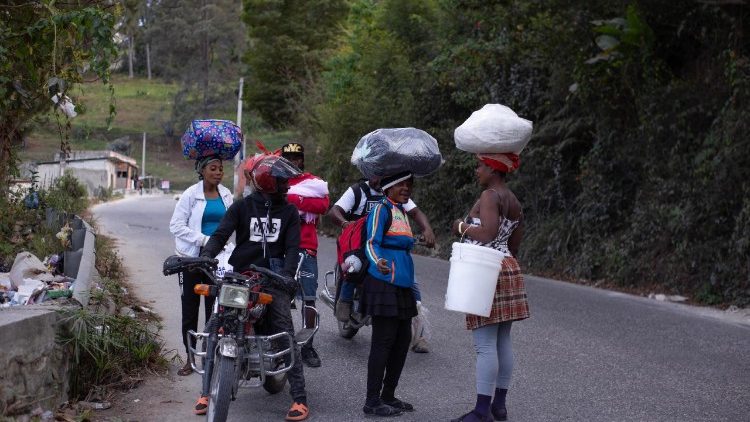 People leave their homes in Kenscoff, Haiti, after two officers were killed by gang members