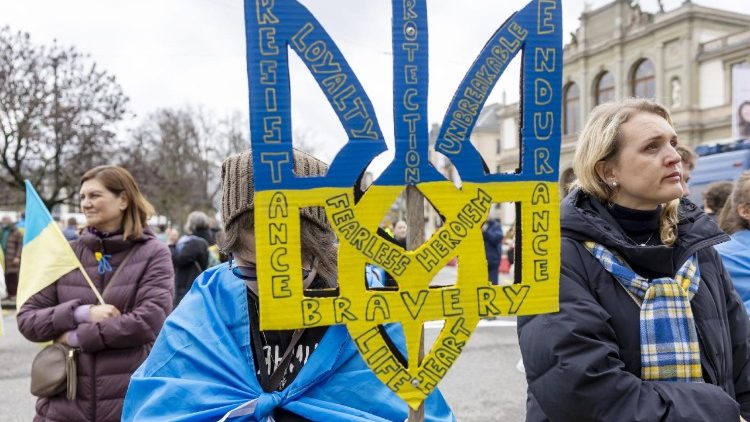 Uma pessoa segurando um símbolo do brasão de armas ucraniano participa de um comício pela Ucrânia para marcar três anos da invasão russa, na Place Neuve em Genebra, Suíça, 23 de fevereiro de 2025. EPA/SALVATORE DI NOLFI