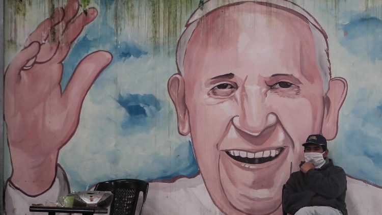 Obdachloser vor eine Wandmalerei, die den Papst verewigt, in einem Slum von Buenos Aires