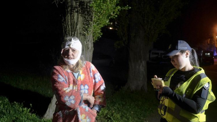 Uma mulher ferida conversa com um policial no local onde um foguete atingiu um prédio residencial em Kiev, Ucrânia, em 24 de abril de 2025, em meio à invasão russa em andamento. A Rússia lançou um ataque noturno em larga escala usando uma combinação de drones e vários tipos de foguetes. Pelo menos duas pessoas morreram e 54 ficaram feridas, incluindo seis crianças, no ataque ao prédio residencial. EPA/SERGEY SHESTAK