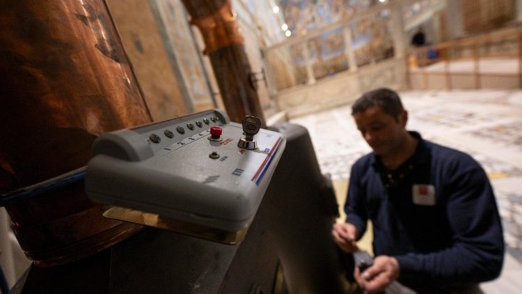 Uma foto divulgada pela mídia do Vaticano em 3 de maio de 2025 mostra trabalhadores conectando a chaminé às estufas instaladas dentro da Capela Sistina, ANSA / VATICAN MEDIA 