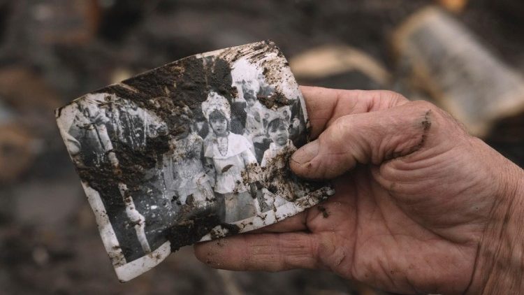 O escultor e morador local Vitaliy Rozhyk segura uma foto de família que encontrou no local de um ataque russo a um prédio privado que matou três crianças, em Korostyshiv, região de Zhytomyr, noroeste da Ucrânia, em 28 de maio de 2025, durante a invasão russa. Em 25 de maio de 2025, um ataque com foguete matou três crianças: Stanislav, de 8 anos, Tamara, de 12, e Roman Martyniuk, de 17. A mãe delas permanece hospitalizada em estado grave; outras 12 pessoas ficaram feridas e mais de 30 casas foram destruídas ou danificadas na região. EPA/ANDREW KRAVCHENKO