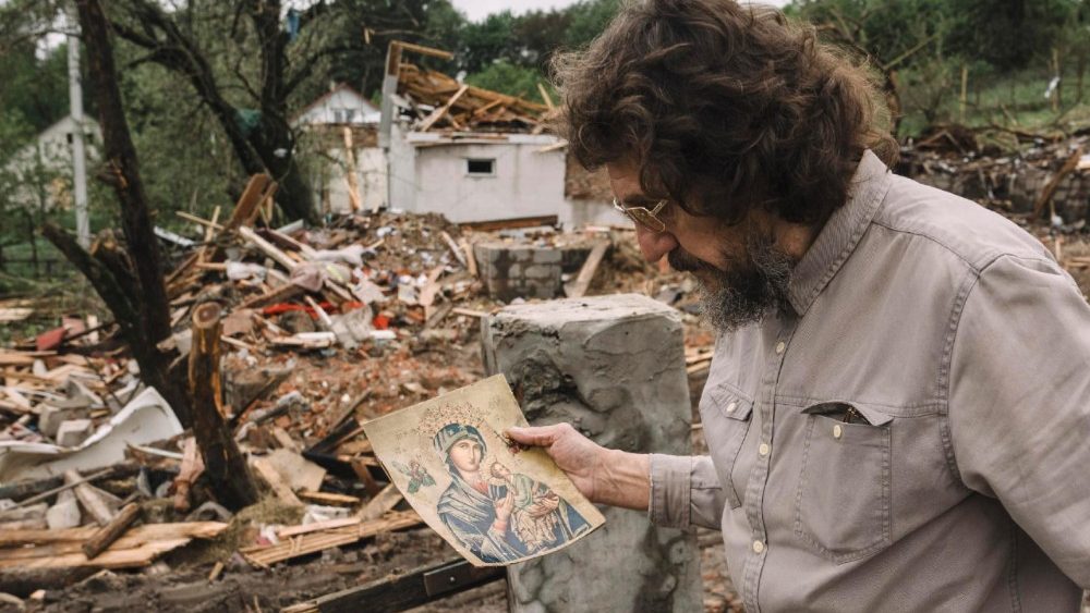O escultor e residente local Vitaliy Rozhyk carrega um ícone encontrado no local onde um ataque russo atingiu uma residência, matando três crianças, em Korostyshiv, região de Zhytomyr, noroeste da Ucrânia, 28 de maio de 2025. EPA/ANDREW KRAVCHENKO