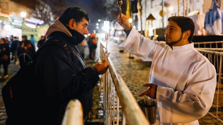 Un sacerdote bendice a un hombre durante una conmemoración del Día de San Cayetano en Buenos Aires,