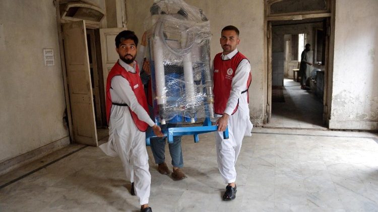 Volunteers load relief goods for people who were affected by flooding from monsoon rains in the Khyber Pakhtunkhwa province