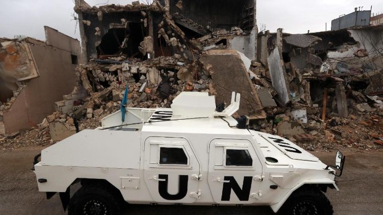  Un mezzo dell'Unifil accanto a un edificio distrutto nel sud del Libano