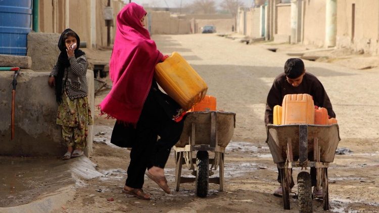Una familia afgana transporta tanques de agua en Kandahar (ANSA)