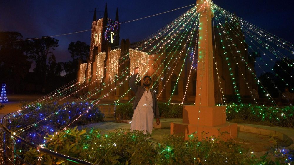 Um cristão paquistanês instala iluminações na fachada da Catedral de São João, em Peshawar, Paquistão, em 23 de dezembro de 2025, em preparação para as celebrações de Natal. EPA/BILAWAL ARBAB