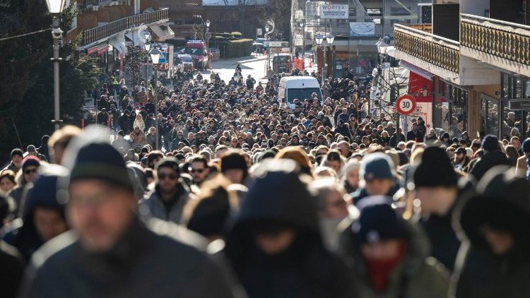 Os enlutados marcham em silêncio da capela onde foi celebrada a missa até o local do incêndio para homenagear as vítimas do incêndio no bar e lounge 'Le Constellation', em Crans-Montana, Suíça, em 4 de janeiro de 2026. Pelo menos 40 pessoas perderam a vida e mais de 100 ficaram gravemente feridas no incêndio que devastou o bar 'Le Constellation' na véspera de Ano Novo, na estância de esqui de Crans-Montana, nos Alpes Suíços. EPA/JEAN-CHRISTOPHE BOTT