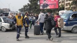 Sírios carregando seus pertences fogem de um bairro em Aleppo, no norte da Síria, em 8 de janeiro de 2026.