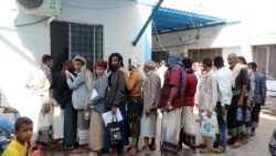 Persone in fila per ricevere aiuti nella città di Aden