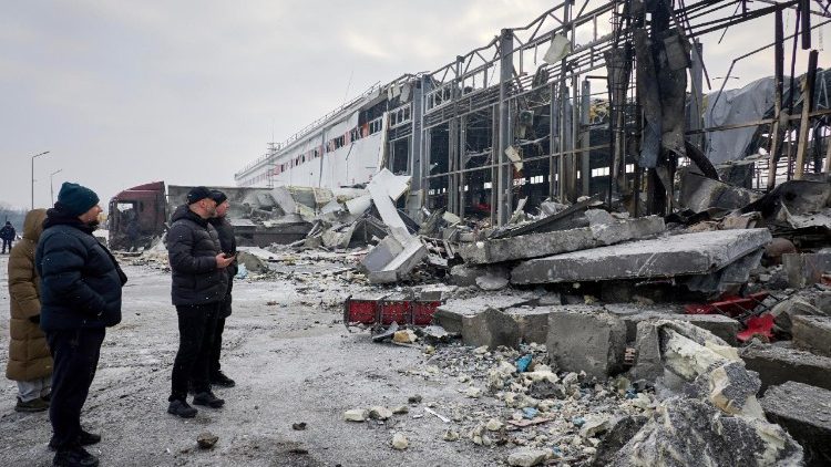 Pessoas observam o local de um ataque russo a um terminal postal em Kharkiv, no nordeste da Ucr&acirc;nia, em 13 de janeiro de 2026, em meio &agrave; invas&atilde;o russa. Pelo menos quatro pessoas morreram e outras seis ficaram feridas ap&oacute;s um ataque russo atingir um terminal da Nova Post (Nova Poshta) em Kharkiv, segundo o Servi&ccedil;o Estatal de Emerg&ecirc;ncia da Ucr&acirc;nia (SESU). EPA/SERGEY KOZLOV