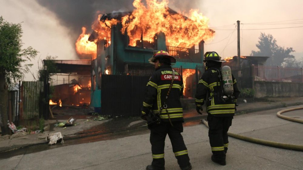 Bombeiros trabalham para extinguir um incêndio em uma casa afetada por incêndios florestais em Penco, Chile, em 18 de janeiro de 2026. Um total de 16 pessoas morreram em vários incêndios florestais que ainda queimam no sul do Chile, nas regiões de Nuble e Biobío, conforme relatado pelo Ministro da Segurança Pública, Cordero. EPA/PABLO HIDALGO