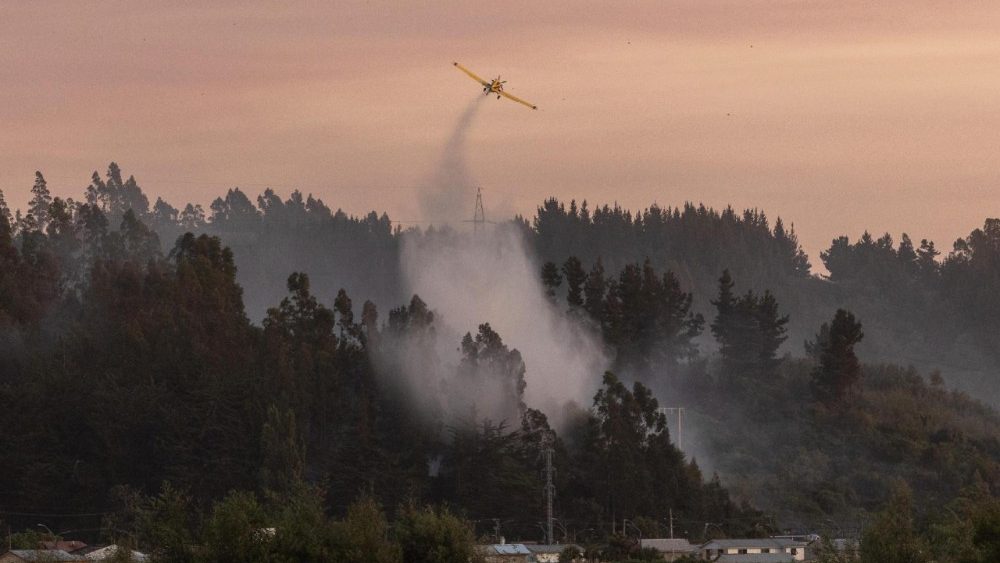 Um avião realiza bombardeio com água em um incêndio florestal em Penco, Chile, em 18 de janeiro de 2026. O presidente chileno, Gabriel Boric, anunciou em 18 de janeiro de 2026 que o número de mortos pelos incêndios florestais nas regiões sulistas de Nuble e Biobío havia subido para 18. EPA/PABLO HIDALGO