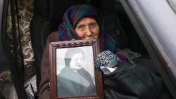 Lidia, 82 anos, de Volchansk, segura seu retrato emoldurado ao chegar a um centro de evacuação em Kharkiv, no nordeste da Ucrânia, em 28 de janeiro de 2026. EPA/SERGEY KOZLOV