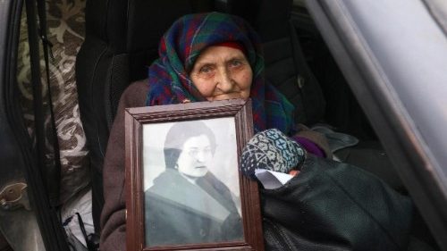 Lidia, 82 anos, de Volchansk, segura seu retrato emoldurado ao chegar a um centro de evacuação em Kharkiv, no nordeste da Ucrânia, em 28 de janeiro de 2026. EPA/SERGEY KOZLOV