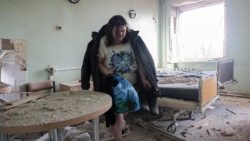 Uma mulher recolhe seus pertences em uma ala danificada de uma maternidade após um ataque russo em Zaporizhzhia, no sudeste da Ucrânia, em 1º de fevereiro de 2026, em meio à invasão russa. EPA/OLEG MOVCHANIUK