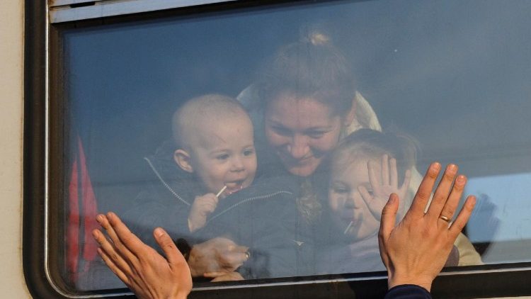 Ucraniana e seus dois filhos despedem-se na Ucrânia na Estação de Lviv, antes de partirem para a Polônia