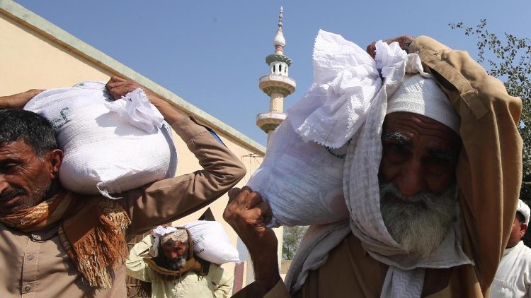 People receive free rations distributed by Crescent Relief Australia, during the Muslims' holy month of Ramadan in Khairpur District, Pakistan