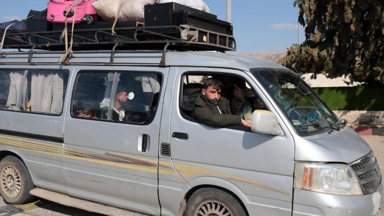 Profughi a bordo di un minivan al confine tra Libano e Siria