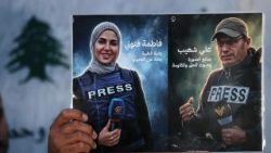 Membro do Sindicato dos Jornalistas exibe imagem de Ali Shoeib e Fatima Ftouni, mortos em ataque israelense no sul do Líbano, durante ato em Beirute