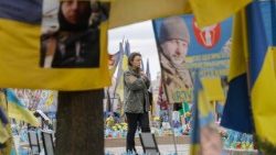 Una donna ucraina vicino a un memoriale dedicato ai soldati ucraini caduti e ai volontari internazionali in piazza dell'Indipendenza a Kyiv, Ucraina