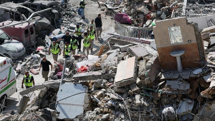 Equipes de resgate caminham em meio aos escombros de prédios danificados um dia após um ataque aéreo israelense que atingiu edifícios em frente ao Hospital Jabal Amel, na cidade de Tiro, Líbano, em 2 de junho de 2026. O Ministério da Saúde libanês informou que, até 1º de junho, os ataques israelenses em todo o Líbano mataram mais de 3.435 pessoas e feriram mais de 10.400, desde o reinício das hostilidades entre Israel e o Hezbollah. (EPA/WAEL HAMZEH)