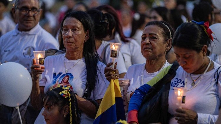 Persone tengono in mano candele durante una messa celebrata in onore delle vittime del doppio terremoto, nella Basilica di Nostra Signora di Chiquinquira (Ansa)