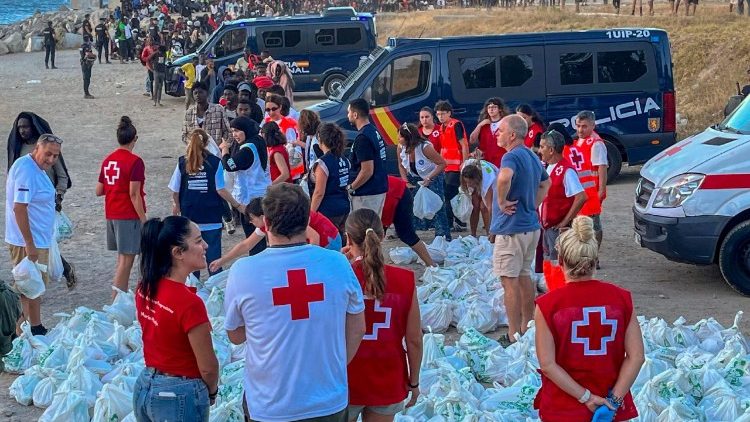 Membros da Cruz Vermelha distribuem alimentos para migrantes na praia El Trampolin, em Ceuta, Espanha, em 4 de agosto de 2026. Segundo autoridades espanholas, cerca de 2.500 migrantes permanecem em Ceuta ap&oacute;s o grande fluxo migrat&oacute;rio da semana passada vindo do Marrocos, muitos vivendo em centros de acolhimento superlotados ou dormindo ao relento em praias e parques. EPA/REDUAN