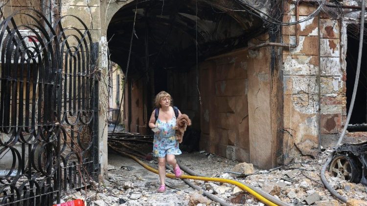 Uma mulher carrega seu cachorro no local de um ataque russo a uma &aacute;rea residencial no centro de Odessa, Ucr&acirc;nia, em 9 de agosto de 2026, em meio &agrave; invas&atilde;o russa. Pelo menos nove pessoas ficaram feridas ap&oacute;s um ataque russo noturno a Odessa, de acordo com a administra&ccedil;&atilde;o militar regional de Odessa. EPA/IGOR MASLO