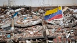 Uma bandeira venezuelana tremula ao vento em meio aos escombros em La Guaira, Venezuela, em 9 de agosto de 2026. La Guaira é o estado mais atingido pelos dois terremotos que atingiram a Venezuela em 24 de junho. EPA/RONALD PENA R