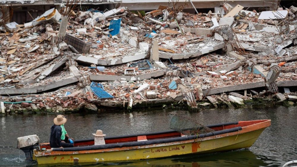 Uma pessoa navega em um barco ao lado de um prédio desabado em La Guaira, Venezuela, em 9 de agosto de 2026. La Guaira é o estado mais atingido pelos dois terremotos que atingiram a Venezuela em 24 de junho. EPA/RONALD PENA R