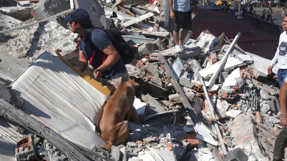 Pessoas caminham entre os escombros de um prédio que desabou após um terremoto em Cali, Colômbia, em 10 de agosto de 2026. Pelo menos 20 edifícios sofreram danos severos em decorrência do terremoto de magnitude 7,4 que atingiu grande parte do país, com epicentro na região do Pacífico. EPA/ERNESTO GUZMAN JR