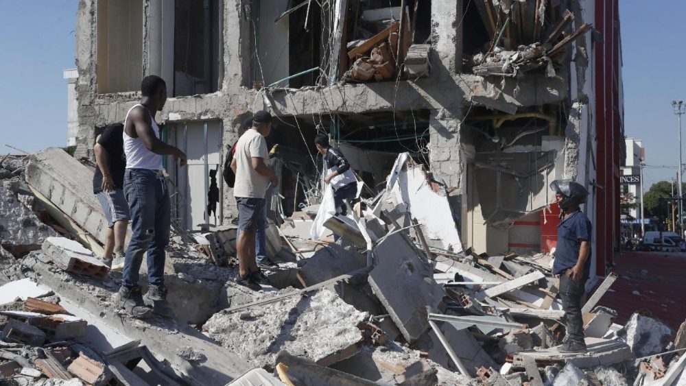 Pessoas caminham entre os escombros de um prédio que desabou após um terremoto em Cali, Colômbia, em 10 de agosto de 2026. Pelo menos 20 edifícios sofreram danos severos em decorrência do terremoto de magnitude 7,4 que atingiu grande parte do país, com epicentro na região do Pacífico. EPA/ERNESTO GUZMAN JR