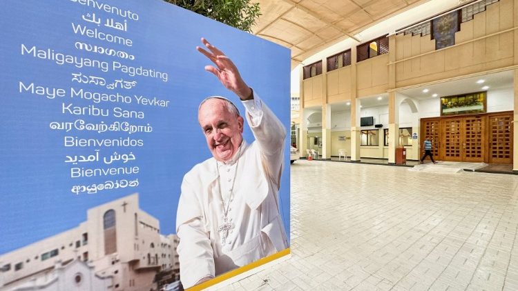 Welcome banners are displayed for Pope Francis at Sacred Heart Catholic Church in Manama