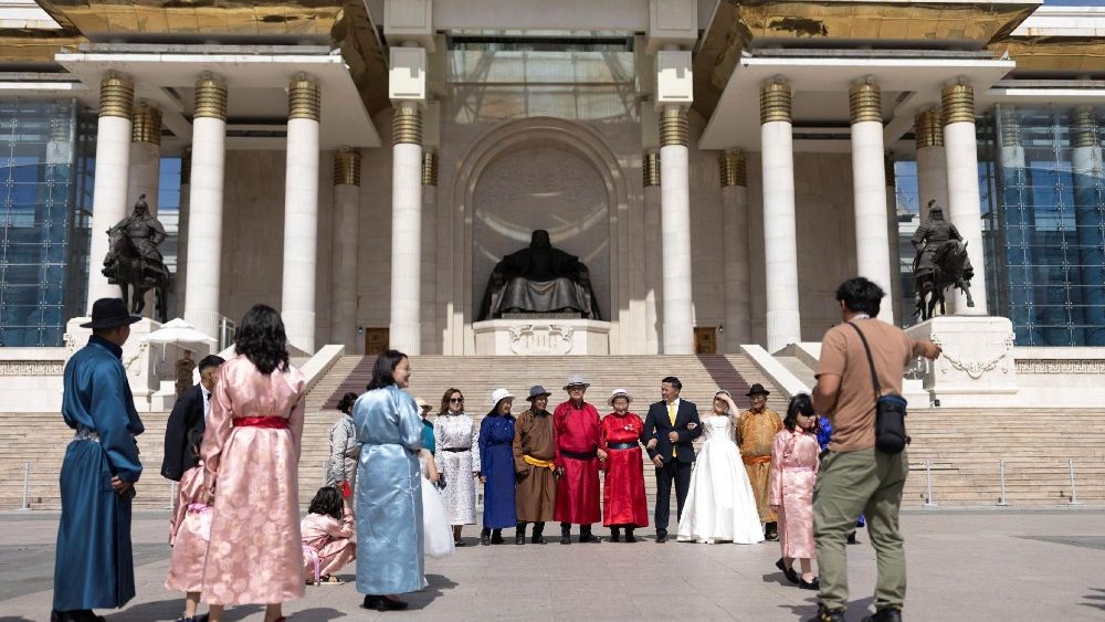 Pessoas que participam de uma celebração de casamento posam para fotos em frente ao prédio do parlamento na Praça Sukhbaatar, um dia antes da chegada do Papa Francisco, em Ulan Bator, Mongólia, 31 de agosto de 2023. REUTERS/Carlos Garcia Rawlins