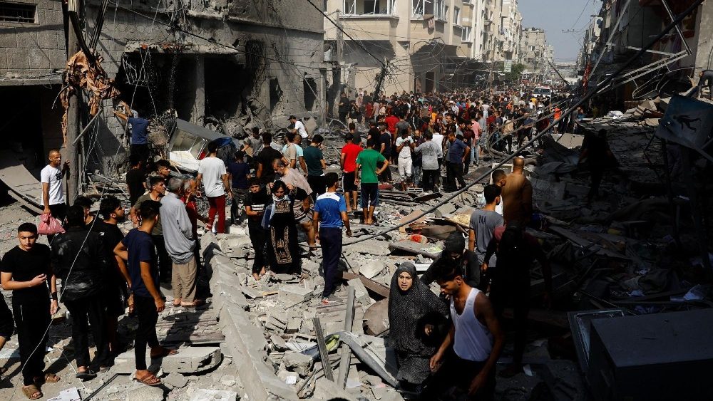 Palestinos se reúnem no local de um ataque israelense em Khan Younis, no sul da Faixa de Gaza, em 24 de outubro de 2023 (Reuters)