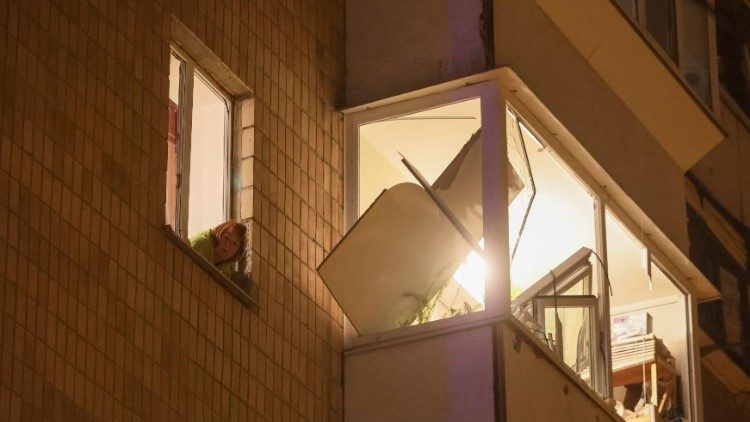 Uma moradora local olha pela janela de seu prédio danificado durante um ataque de míssil russo, em meio ao ataque da Rússia à Ucrânia, em Kiev, Ucrânia, 13 de dezembro de 2023. REUTERS/Gleb Garanich