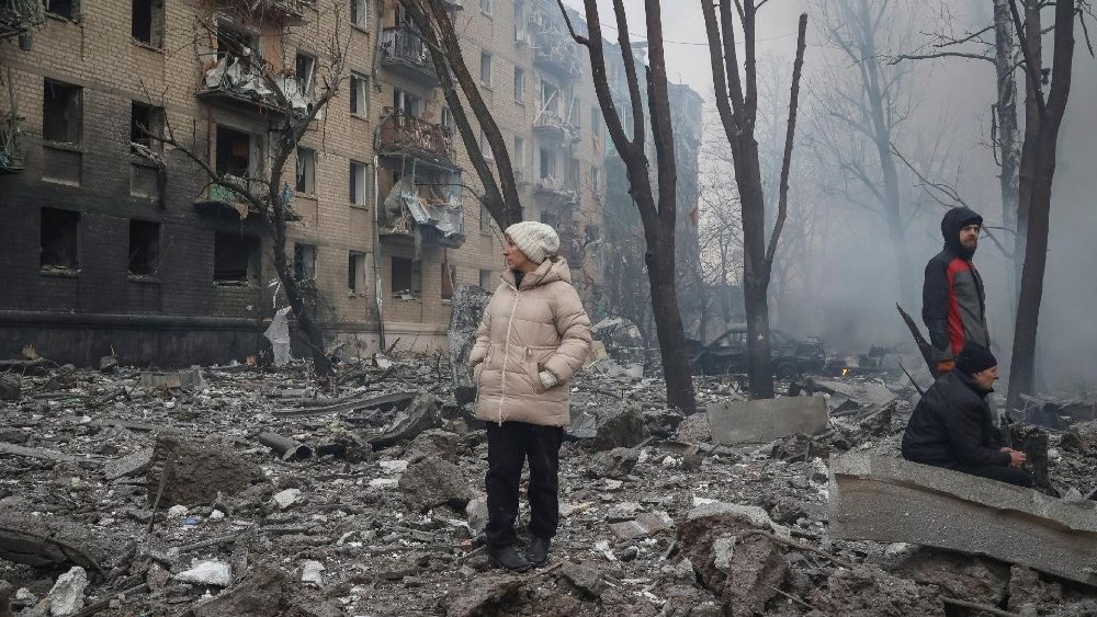 Moradores locais ficam perto de seu prédio danificado durante um ataque de míssil russo, em meio ao ataque da Rússia à Ucrânia, em Kharkiv, Ucrânia, em 23 de janeiro de 2024. REUTERS/Sofiia Gatilova