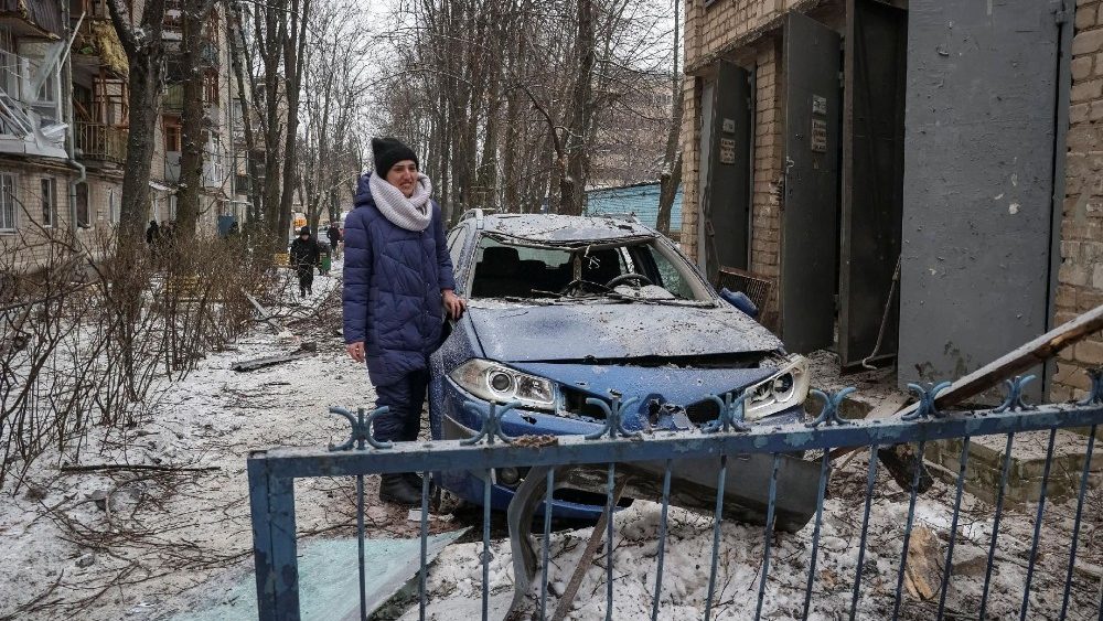 Um residente local fica perto de um carro destruído em um prédio de apartamentos danificado durante um ataque de míssil russo, em meio ao ataque da Rússia à Ucrânia, em Kharkiv, Ucrânia, 23 de janeiro de 2024. REUTERS/Sofiia Gatilova