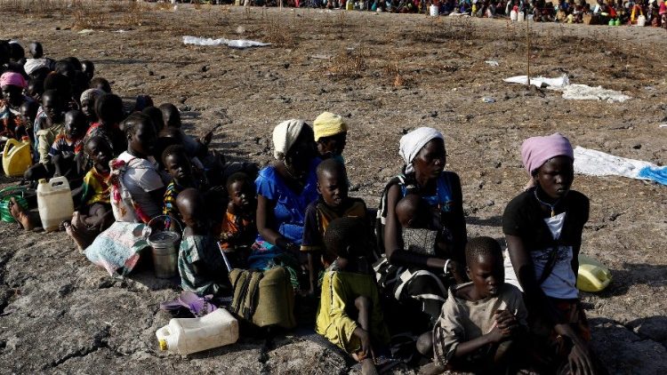 Women and children wait to be registered prior to a food distribution 