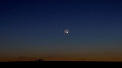 Neumond über Rauchschleiern durch Beschuss in der Region Donetzk