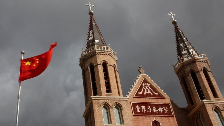 Vor einer Dorfkirche weht die chinesische Flagge