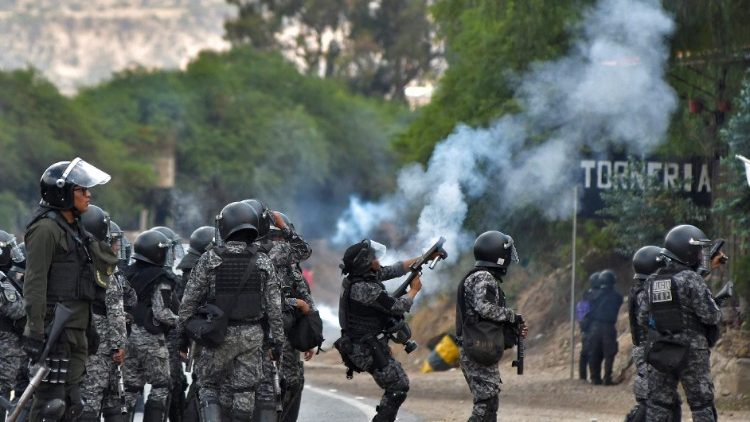 Oficiales de la policía en Bolivia intentan desmantelar un barricada en medio de las protestas por la crisis económica y política.