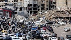 People gather near damaged buildings in southern Beirut after an Israel-Hezbollah ceasefire took effect