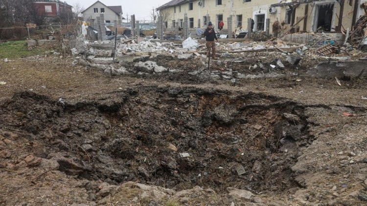 Um homem filma uma cratera que apareceu após um ataque de míssil russo em uma área residencial, em meio ao ataque da Rússia à Ucrânia, nos arredores de Odesa, Ucrânia, em 28 de novembro de 2024. REUTERS/Nina Liashonok