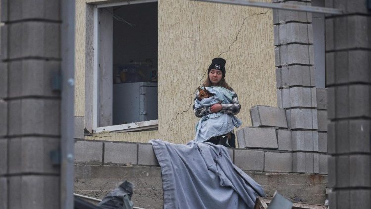 Uma moradora segura um cachorro ao lado de sua casa danificada por um ataque de míssil russo, em meio ao ataque da Rússia à Ucrânia, nos arredores de Odesa, Ucrânia, em 28 de novembro de 2024. REUTERS/Nina Liashonok